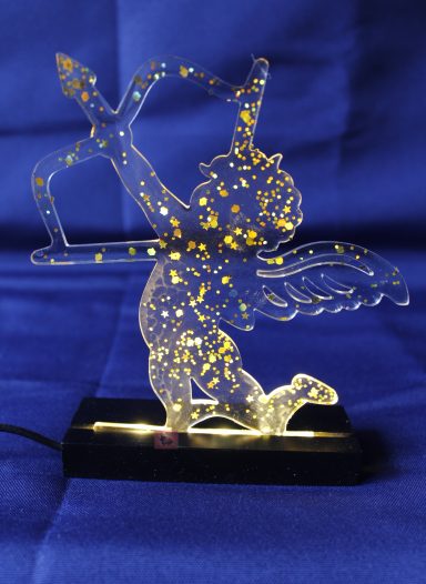 Durchsichtige Statue eines geflügelten Engels mit Pfeil und Bogen, beleuchtet.