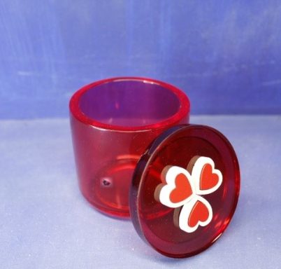 Roter, transparenter Behälter mit einem Deckel und drei roten Herzen darauf.