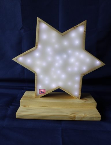 Leuchtender Stern mit weißen Lichtern auf einem Holzsockel.