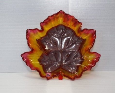 Braune Blattschale mit roter Innenseite, umgeben von weißem Kies.