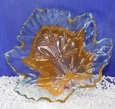 Glasplatte in Form eines Blattes mit orangefarbener Färbung und klaren Rändern.